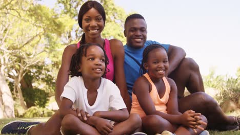 Die-Süße-Familie-Sitzt-Und-Lächelt-In-Die-Kamera