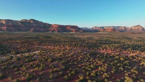 Bushes-On-Red-Desert-Landscape-Of-Sedona-In-Arizona-At-Sunset---aerial-drone-shot