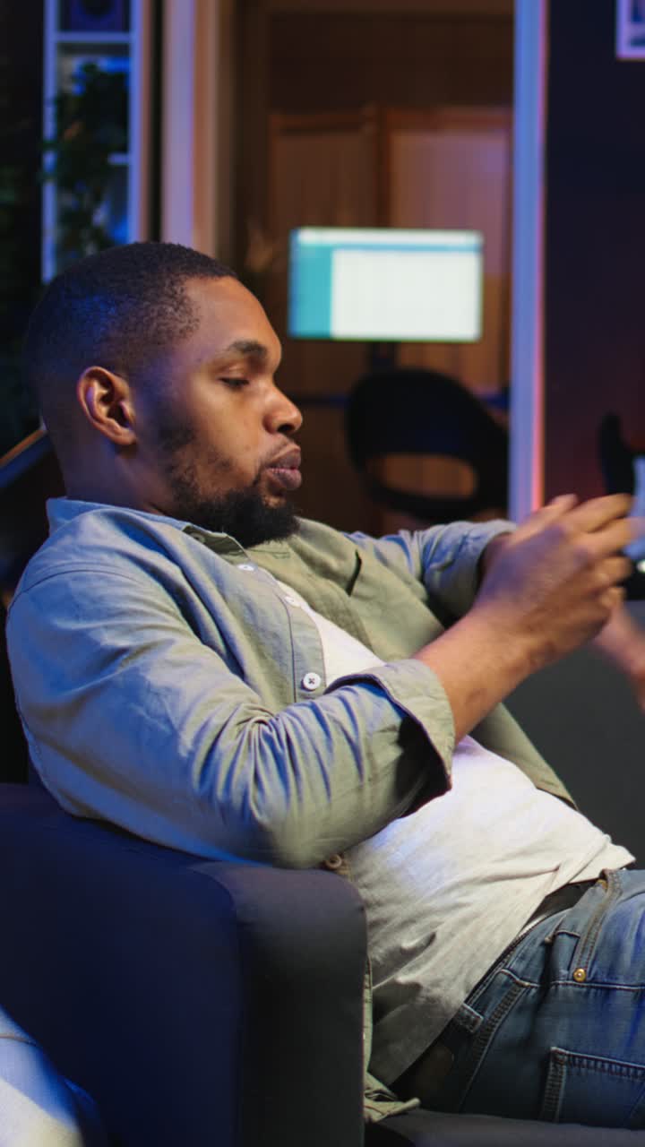 Vertikal video: Smilende afroamerikansk mand afholder virtuelt familiemøde online.