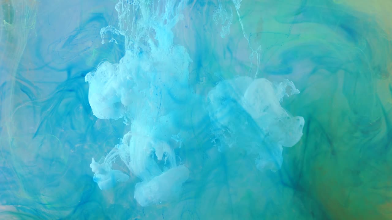 распространение синей, зеленой и белой краски в жидком розовом пространстве.