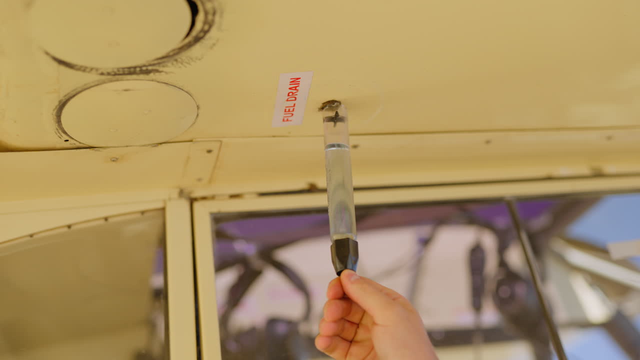 Hand Draining Fuel from Aircraft Wing for Preflight Inspection