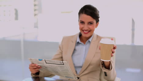 Hermosa-Y-Relajada-Mujer-De-Negocios-Tomando-Café-Mientras-Lee-El-Periódico.