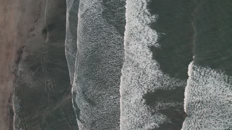 static bird's eye view of waves breaking gently on iceland shoreline