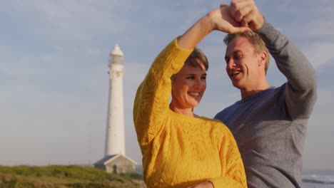 Pareja-Bailando-Junto-Al-Mar-Cerca-De-Un-Faro