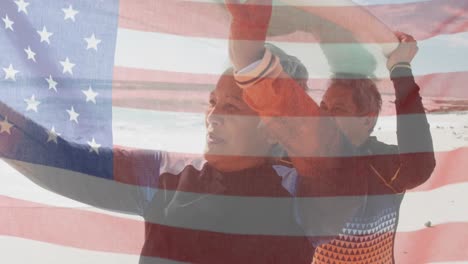 Animation-of-flag-of-united-states-of-america-over-senior-biracial-couple-with-surfboard-on-beach