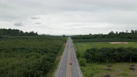 Vista-Aérea-De-La-Carretera-En-El-Campo-En-Un-Día-Nublado,-Movimiento-Hacia-Adelante