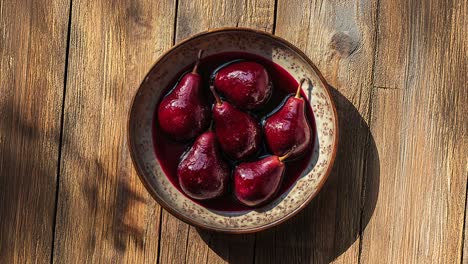 cuenco de peras cocidas en vino rojo en una mesa rústica