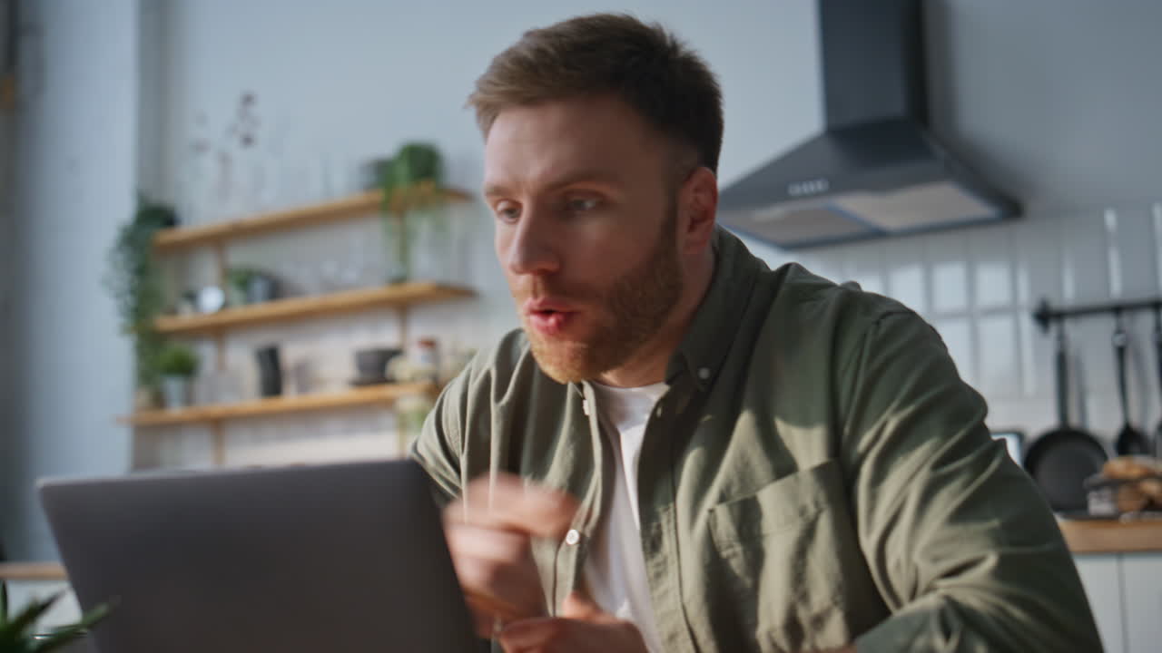 Dissatisfied manager videocalling laptop holding papers at home kitchen closeup