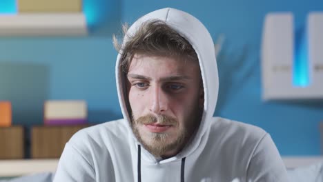 un joven deprimido y con problemas pensando mirando a la cámara.