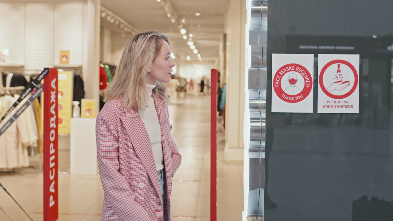 Woman Putting On Face Mask Before Entering Clothing Store
