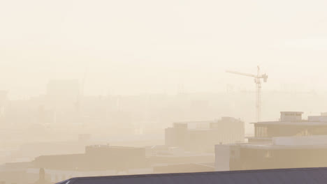 vista general del paisaje urbano con edificios y sitios de construcción cubiertos de niebla