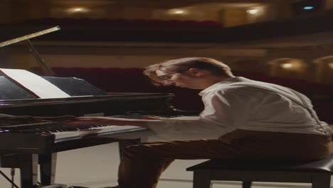 vertical shot of musician playing piano on stage