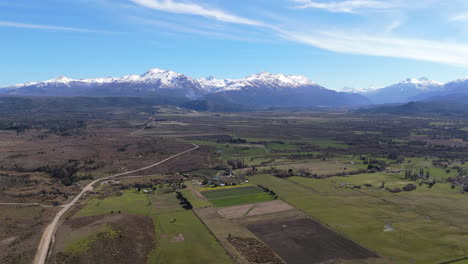 aerial patagonian landscape, snowy mountains over tulip fields of argentina, chubut province