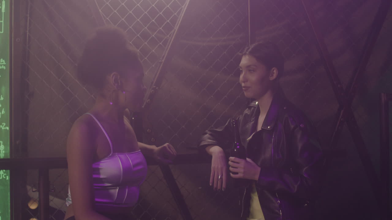 Two Multiethnic Girls Talking To Each Other At Disco