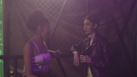 dos chicas multiétnicas hablando entre ellas en la discoteca