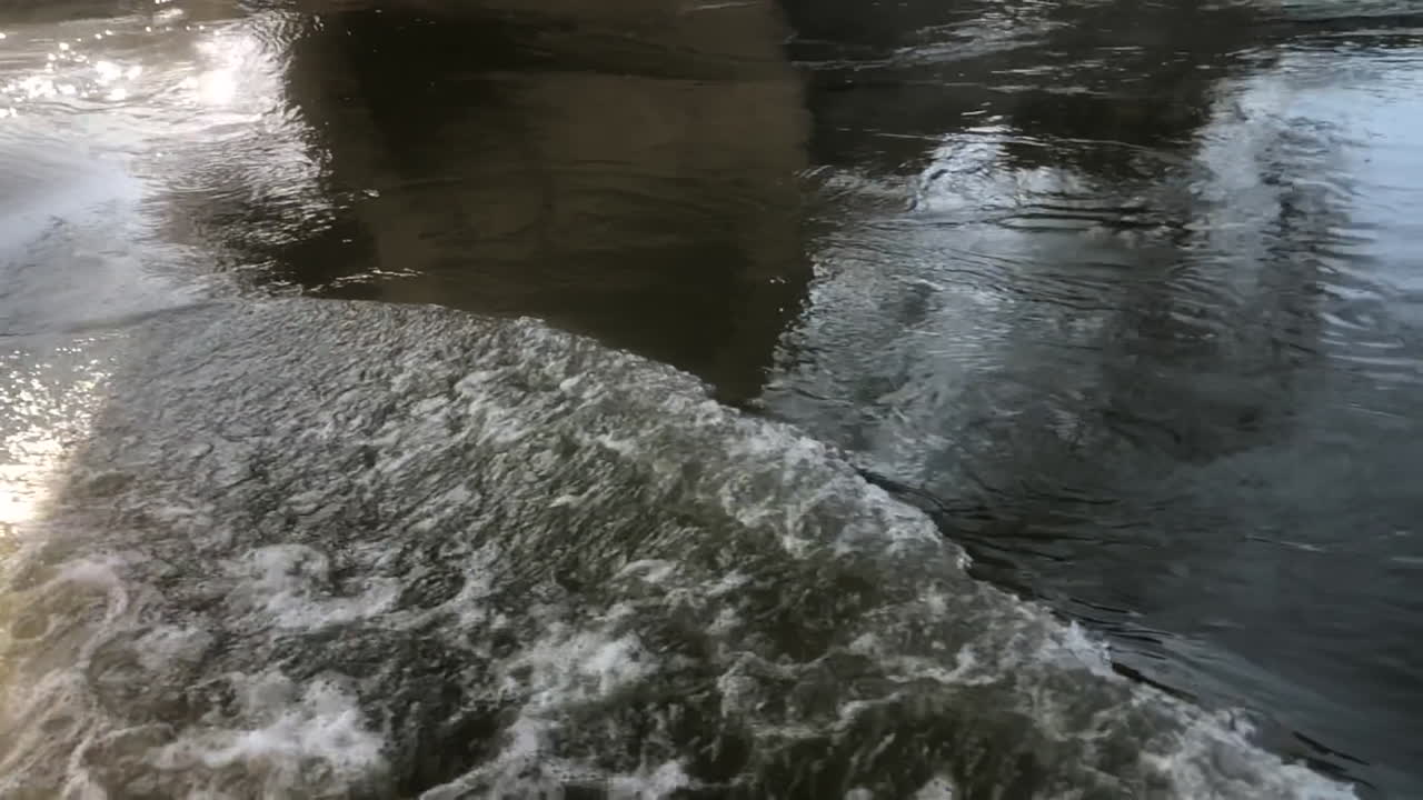 Peaceful stream of water flowing under a bridge on a sunny day