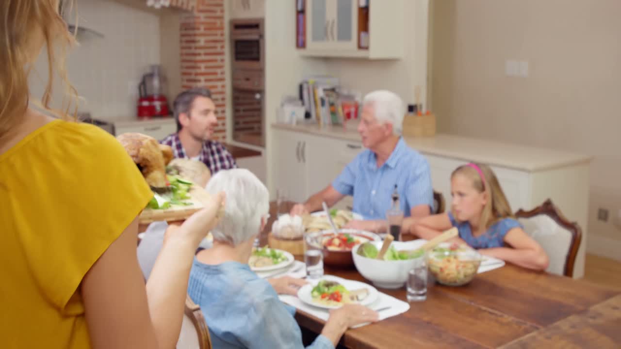 Smiling woman putting chicken on the table
