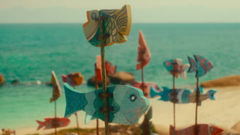 colorful wooden fish windmills on a tropical beach