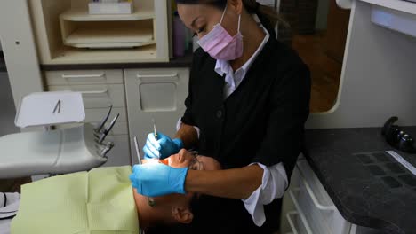 Female-dentist-examining-a-patient-with-tools-4k