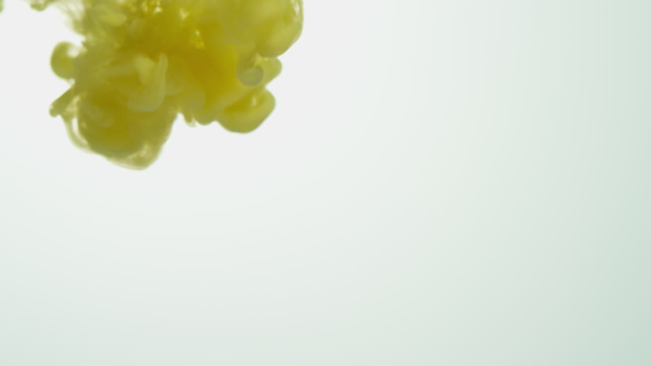 노란색 페인트 또는 염료가 색 배경에 물에 떨어지면 회전하는 다채로운 연기 배경을 만니다.