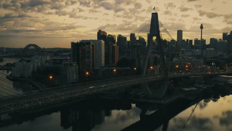 Drone-aerial-view-of-traffic-flowing-over-a-suspended-bridge-across-a-river