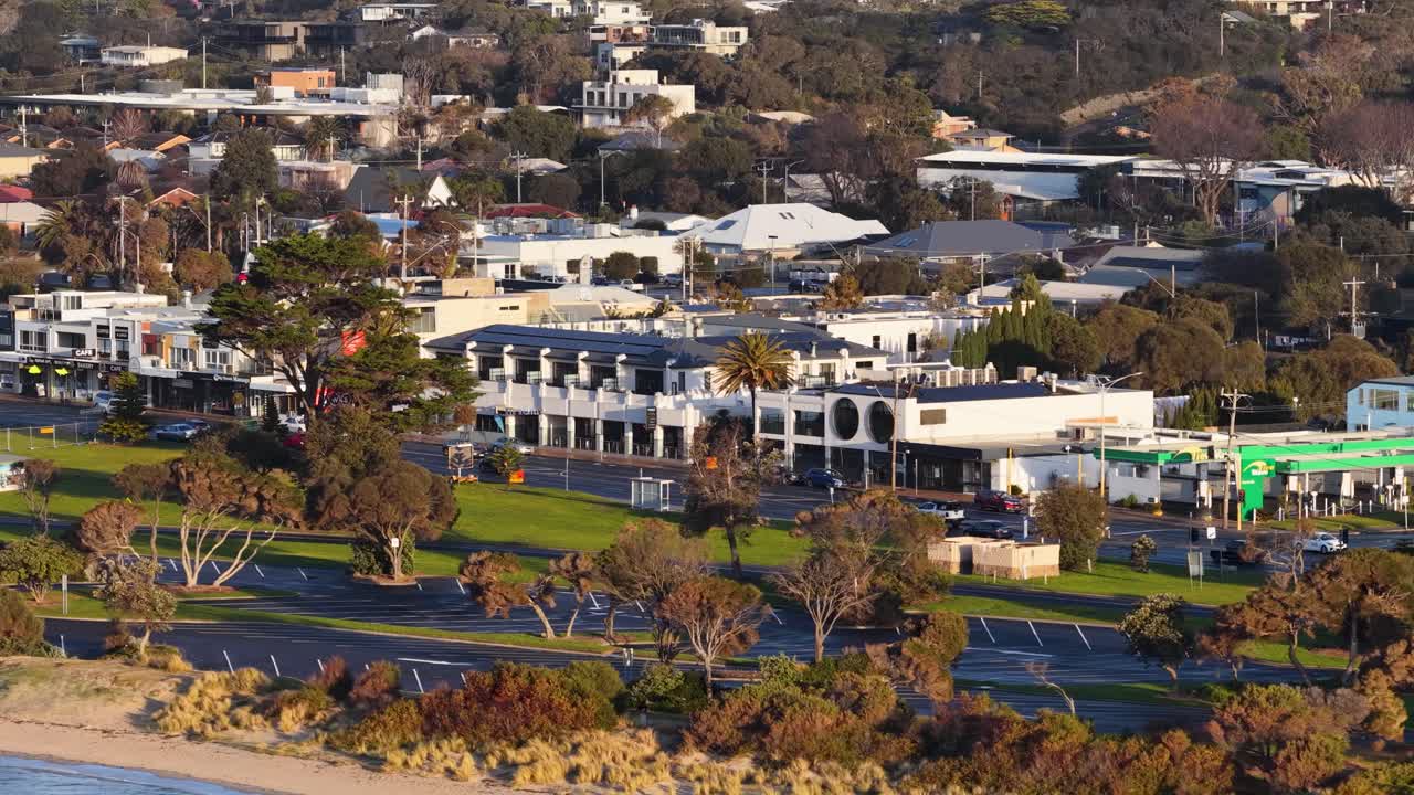 Wide aerial shot slowly panning over Rye town buildings, trees, and streets in golden sunlight