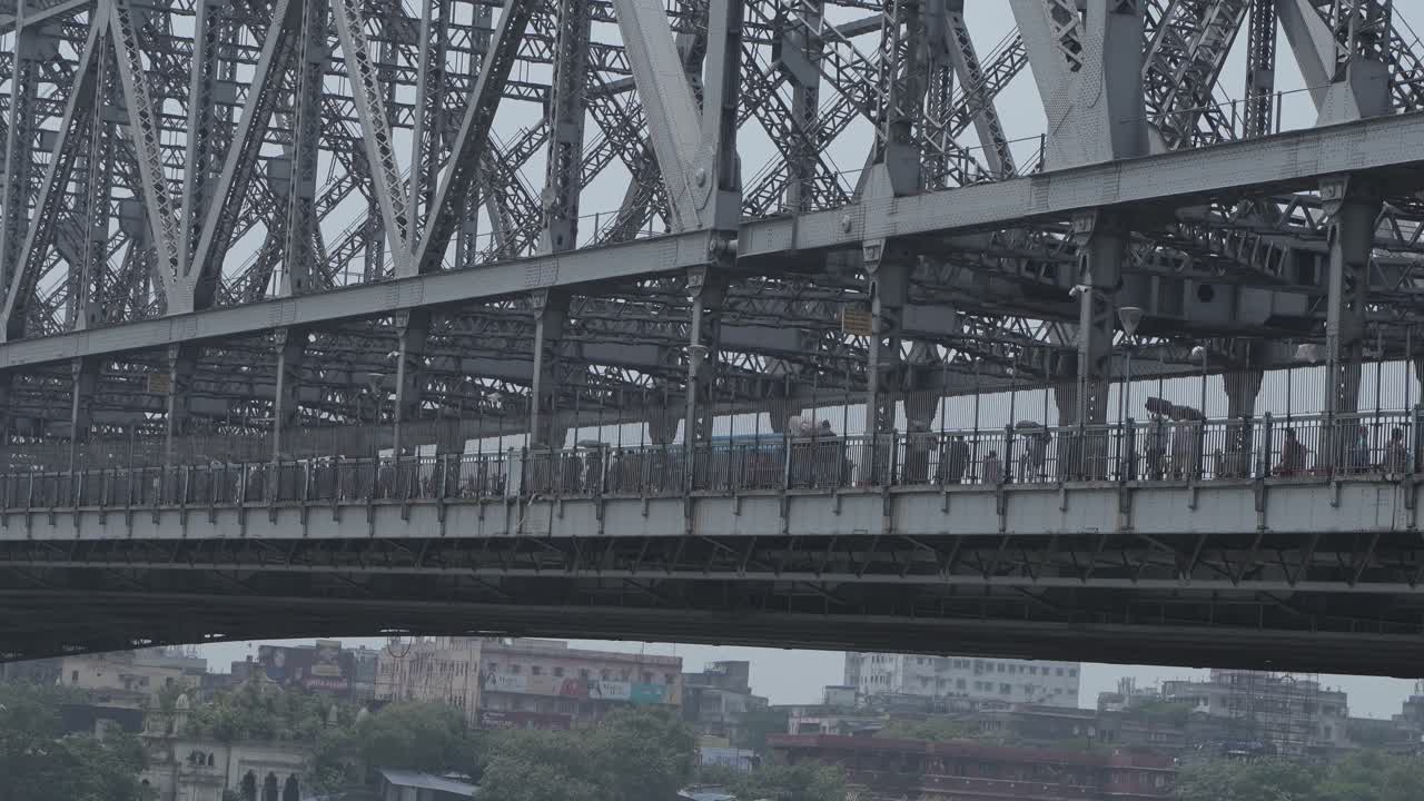 View of Howrah Bridge in Kolkata, India with people walking