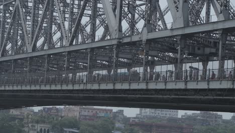 view of howrah bridge in kolkata, india with people walking