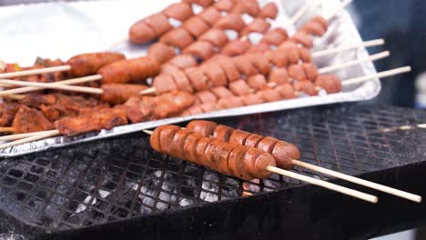 파나마의 거리 음식 맛: 인기있는 테이크아웃 장소에서 판매자가 걱거리는 그릴 위에 개진 고기를 회전시키고 있습니다.