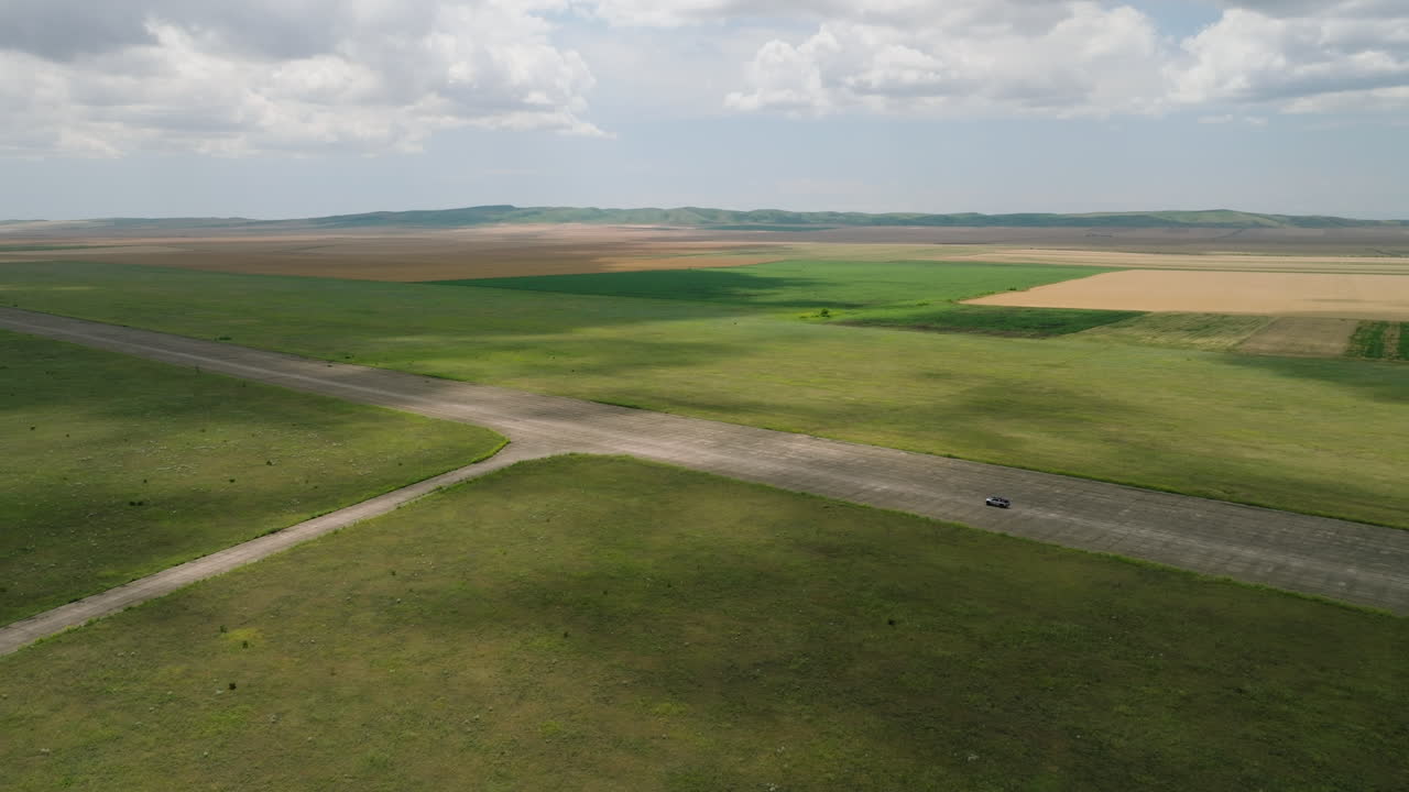 Car driving on runway of abandoned Shiraki military airfield, Georgia