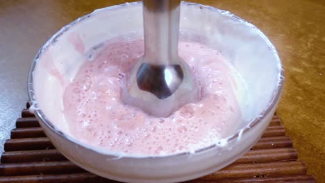 huevos batidos con azúcar y fresas usando un mezclador. cámara lenta con disparo de seguimiento de rotación.