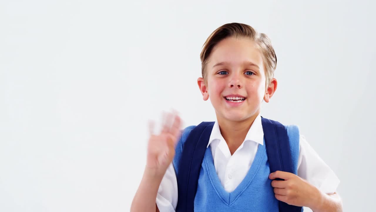Porträt eines lächelnden Schuljungen, der winkt