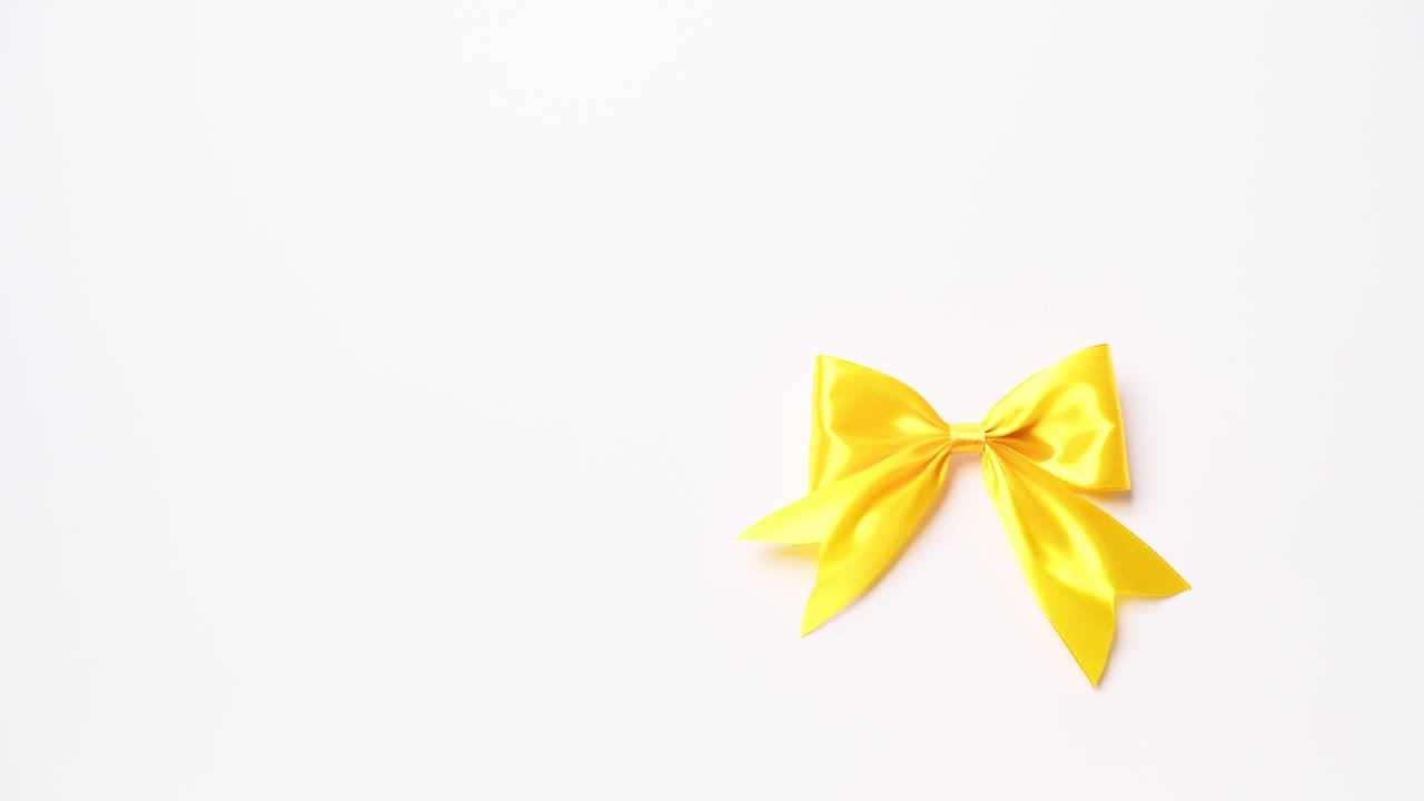 Dettaglio della mano maschile che tiene un nastro giallo su sfondo bianco