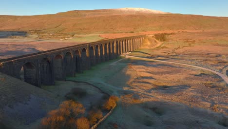 Bögen-Der-Eisenbahnbrücke-Beleuchtet-Durch-Sonnenaufgangslicht