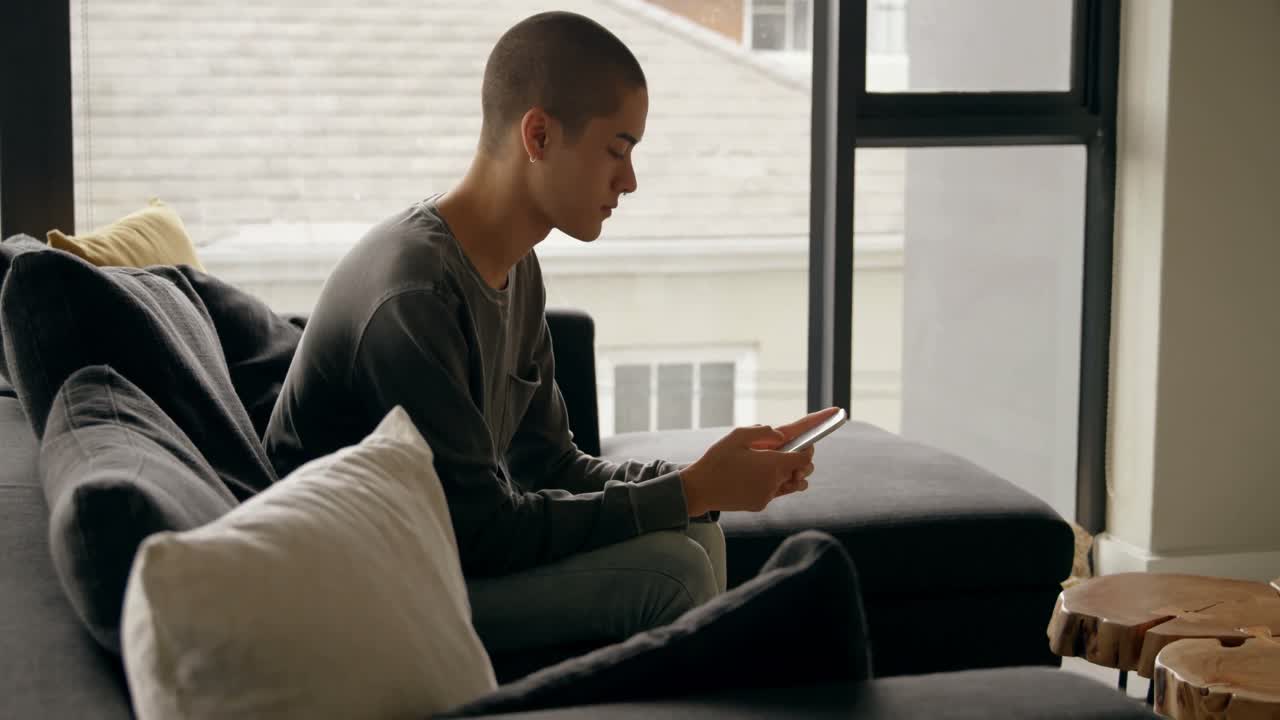 joven usando el móvil en casa 4k
