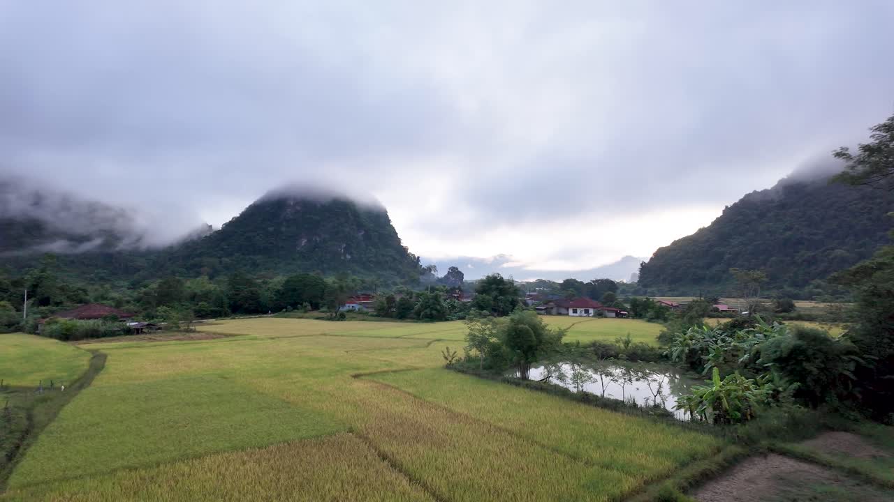 Scenic view of rice fields and mountains in Vang Vieng Laos under a cloudy morning sky