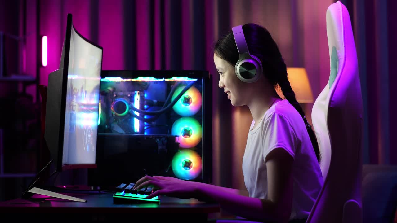 Giocatrice adolescente asiatica entusiasta festeggia la vittoria mentre gioca a un videogioco al computer.