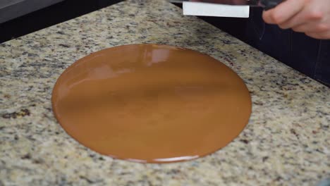 tempering chocolate on a marble surface with tools for a smooth texture