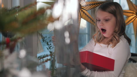 sorpresa de la mañana de navidad, niña feliz abriendo regalos