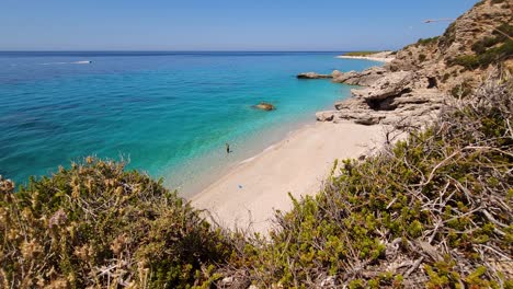 paradise beach with white pebble washed by blue turquoise sea, tourist spot for summer vacation in mediterranean coastline