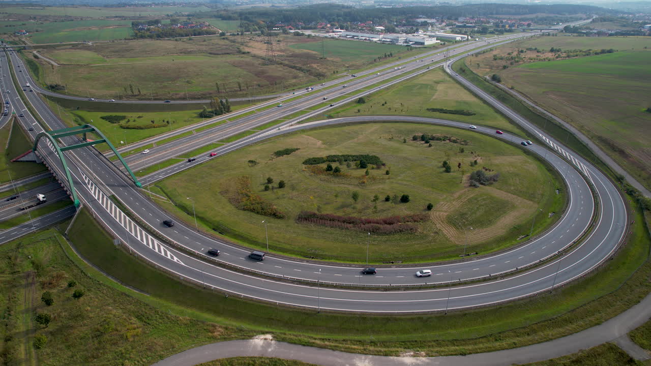 vista aérea del tráfico en la autopista y la intersección en la zona rural de polonia - ciudad de gdansk en segundo plano