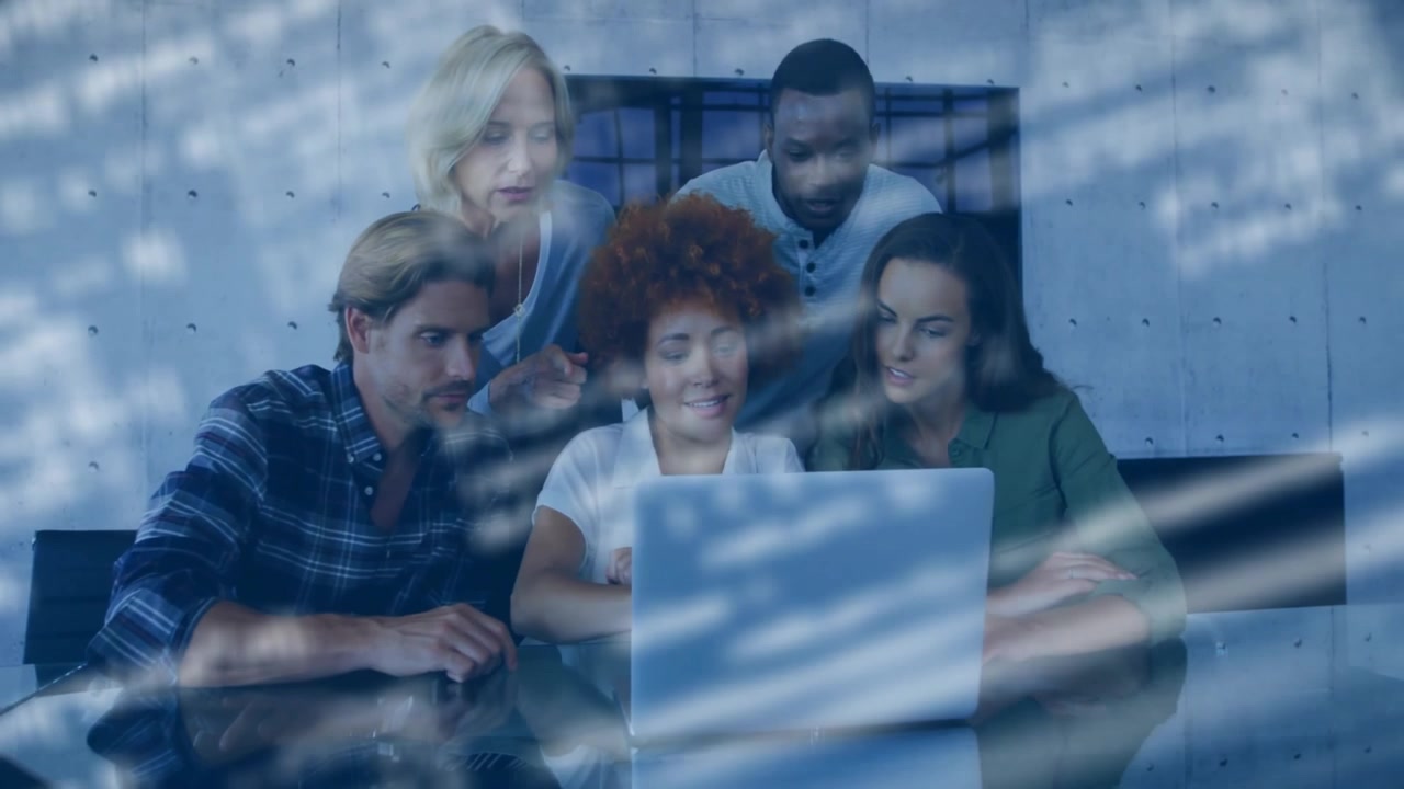 Team gathering around laptop as reflections clear, woman swiping trackpad animating business chart