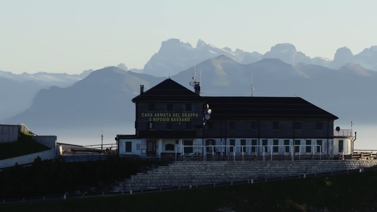Mountain hut with Dolomites in background; serene, outdoor, travel feel