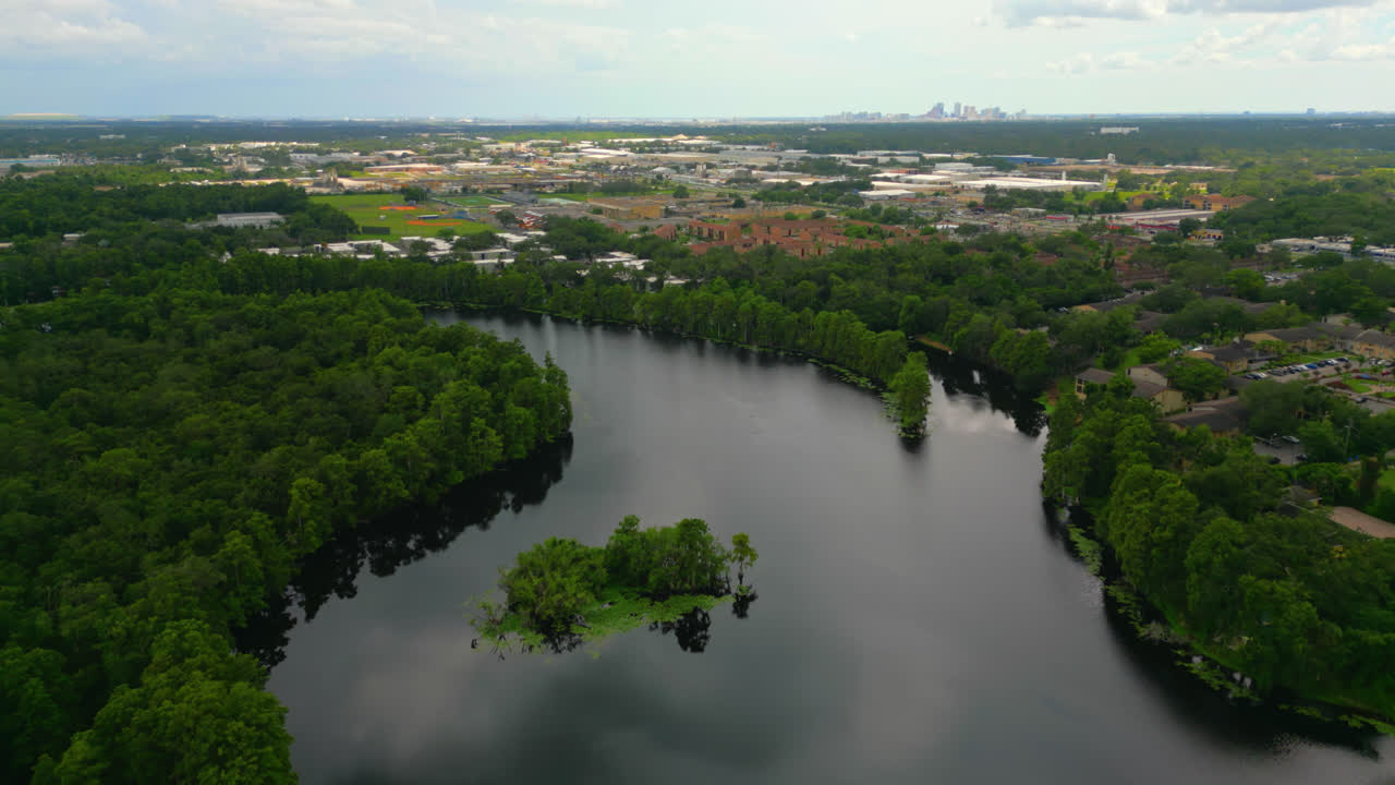 Wide Aerial Establishing Shot Over The Hillsborough River With Tampa Neighborhood and Skyscrapers in the far distance In Florida, USA