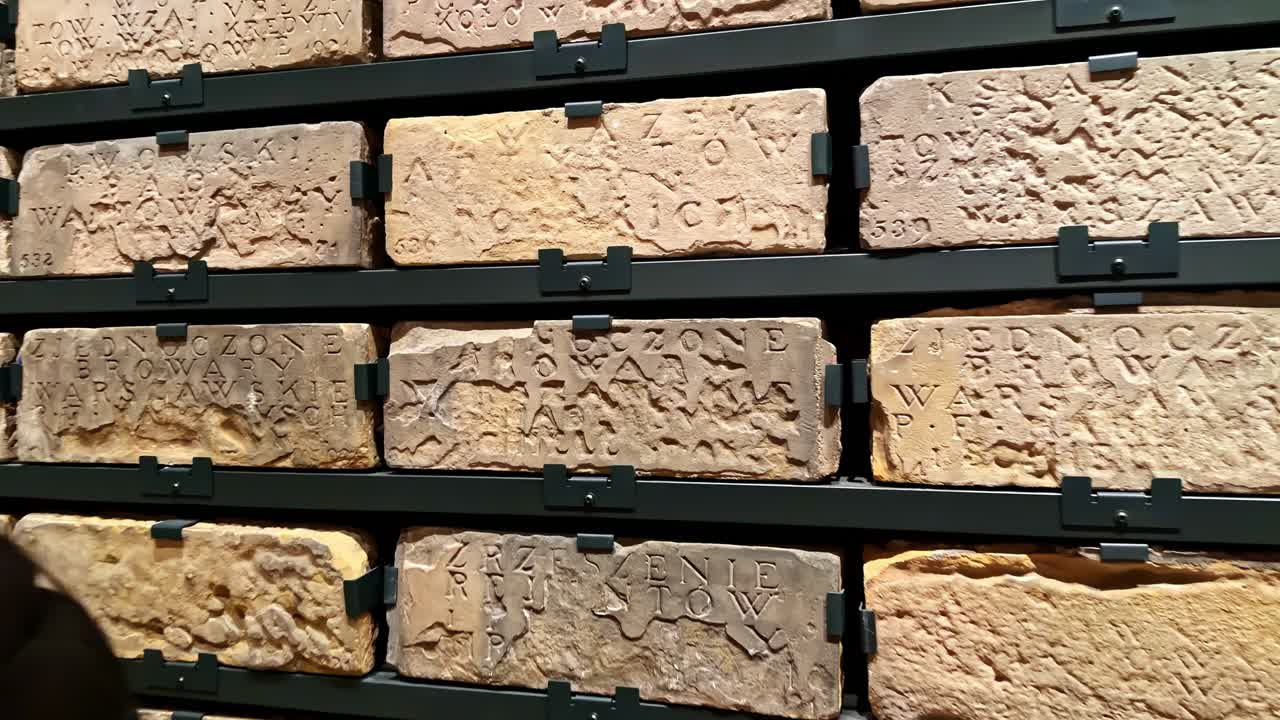 Tourist documents carved medieval stone tablets inside a historic castle exhibition hall