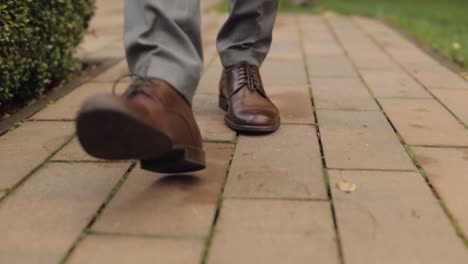 Piernas-De-Un-Hombre-De-Negocios-Elegante-Con-Zapatos-De-Cuero-Caminando-Por-El-Callejón-Del-Parque-En-Un-Cálido-Día-De-Otoño,-Cámara-Lenta