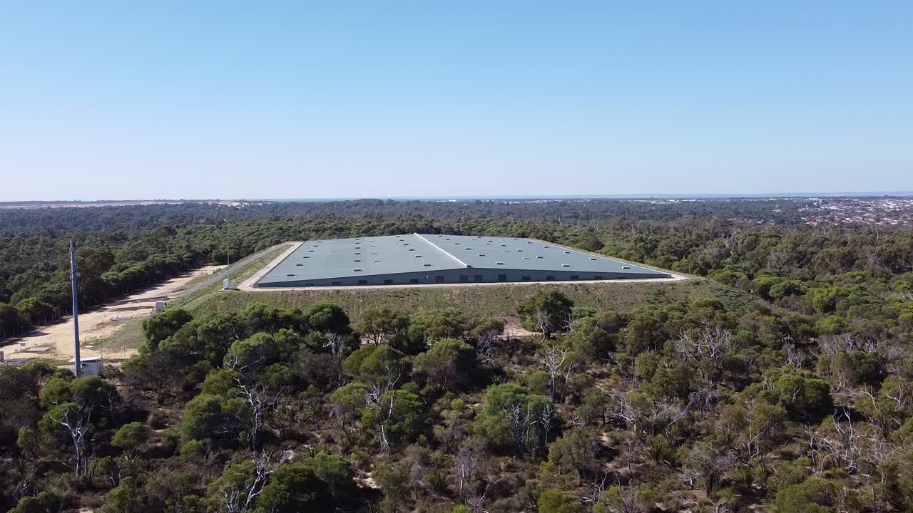 techo cerrado de un depósito de agua en australia rodeado de árboles y cielo azul de fondo