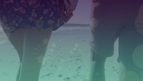 animation of light spots over caucasian couple walking and holding hands