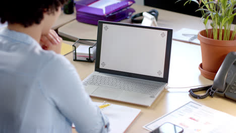 Focused-biracial-casual-businesswoman-having-laptop-video-call-with-copy-space-in-slow-motion