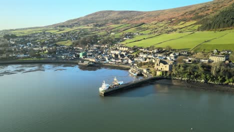 Carlingford-town-with-serene-water-and-rolling-hills-at-sunrise,-aerial-view